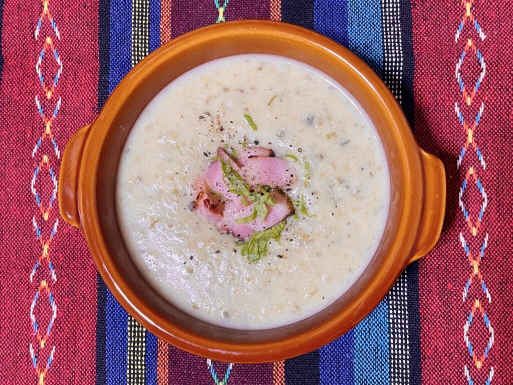 真上から見下ろしたスープの写真。中心に焼きベーコンがのせられている。